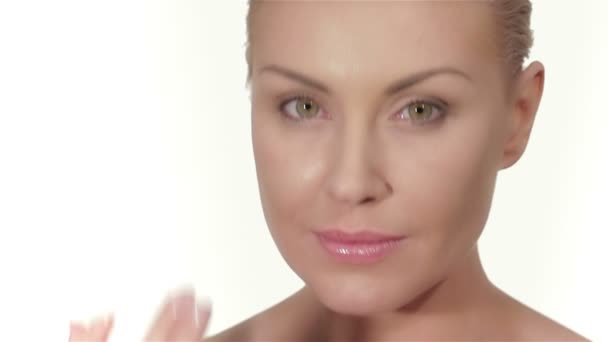 Mujer joven aplicar la crema para la cara
 - Metraje, vídeo