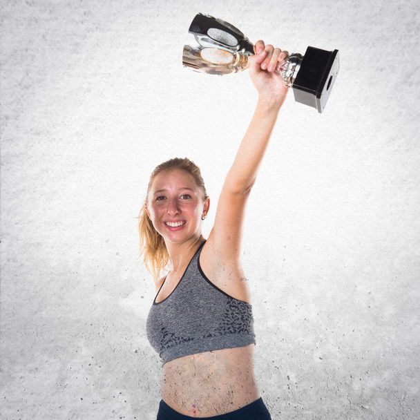 Sport girl holding a trophy - Фото, изображение
