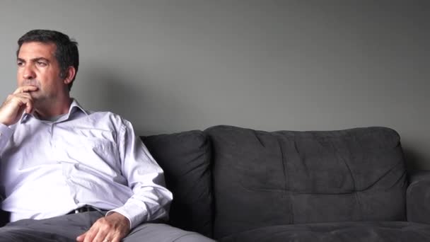 Мужчина за сорок сидит на диване расстроенный
 - Кадры, видео