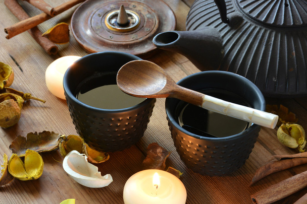 cups of black tea accompanied by incense - Foto, afbeelding