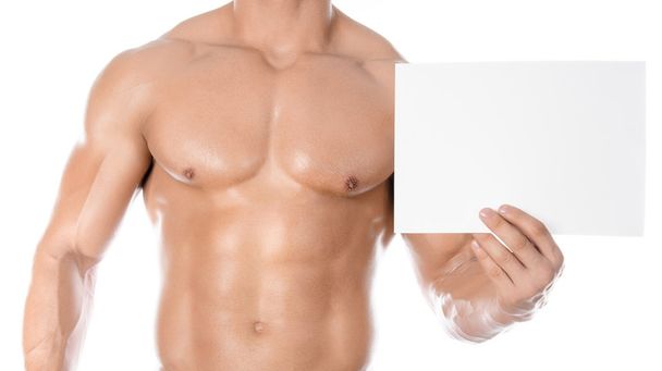 Bodybuilding und Werbung: ein netter starker Bodybuilder mit einer weißen Karte auf weißem Hintergrund im Studio - Foto, Bild