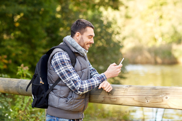 happy man with backpack and smartphone outdoors - Fotoğraf, Görsel