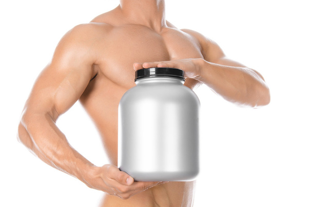 Bodybuilding and Sports theme: handsome strong bodybuilder holding a plastic jar with a dry protein and showing gesture isolated on white background in studio - Foto, immagini