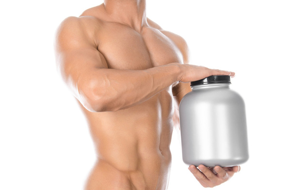 Bodybuilding and Sports theme: handsome strong bodybuilder holding a plastic jar with a dry protein and showing gesture isolated on white background in studio - Foto, Bild