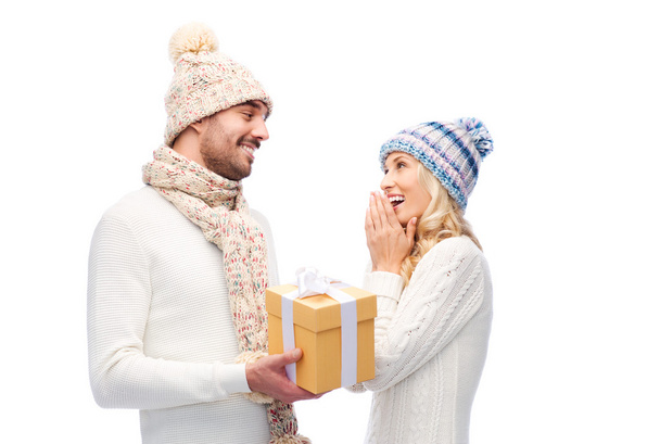 smiling couple in winter clothes with gift box - Zdjęcie, obraz