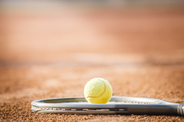 Μπάλα του τένις σε ένα raquet σε άμεσο ηλιακό φως, γεγονός που υποδηλώνει ένα μεγάλο παιχνίδι - Φωτογραφία, εικόνα