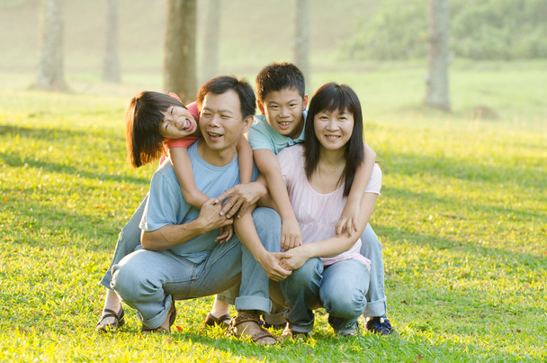 Famiglia giocosa e sorridente nel parco
 - Foto, immagini