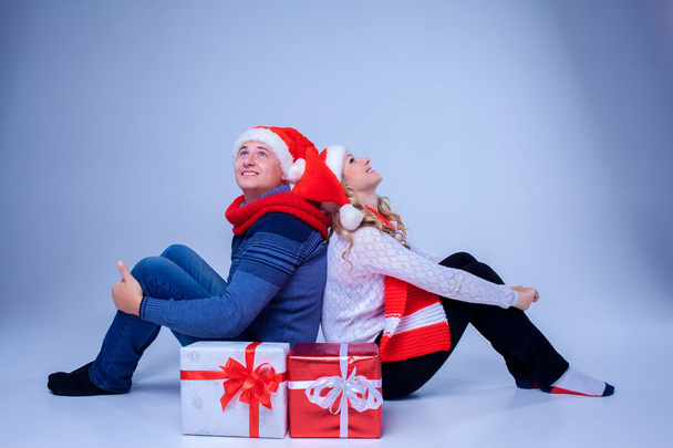 Adorável casal natal sentado com presentes
 - Foto, Imagem