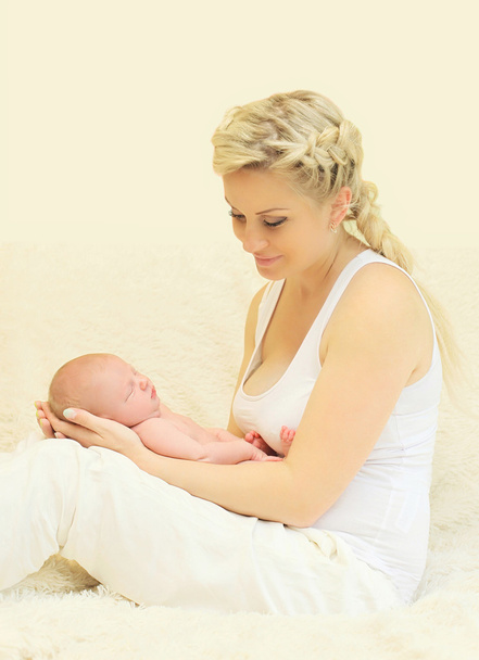 Щаслива усміхнена мати тримає руки сплячого немовляти вдома
 - Фото, зображення