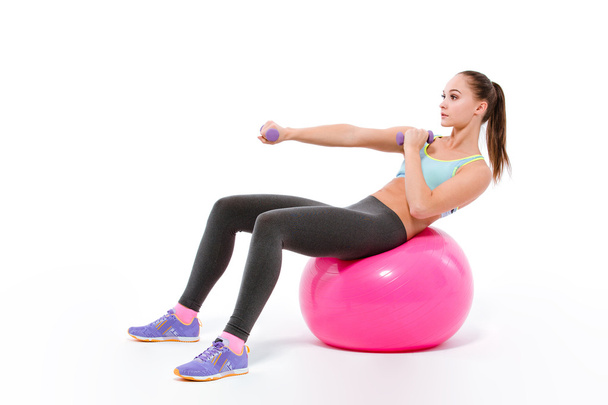 Woman doing exercises with dumbbells on fitness bal - Foto, Imagem