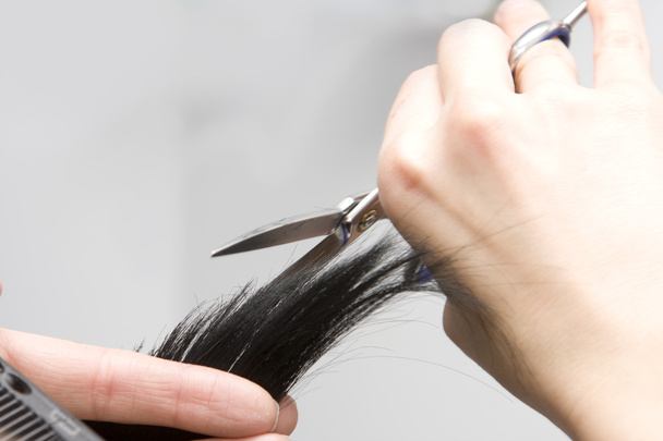 Hairdresser's hands cutting hair. - Fotó, kép