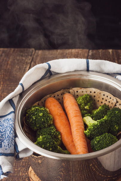 Steamed broccoli and carrots in the pot with steam - Foto, immagini