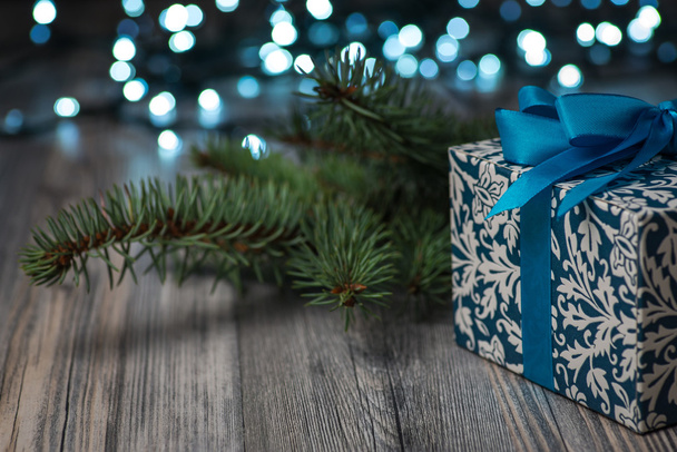 Винтажная рождественская подарочная коробка с голубым бантом на деревянной поверхности
 - Фото, изображение