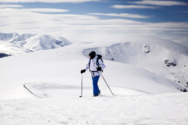 クロスカントリー スキーヤー - 雪に覆われた山を背景に - 写真・画像