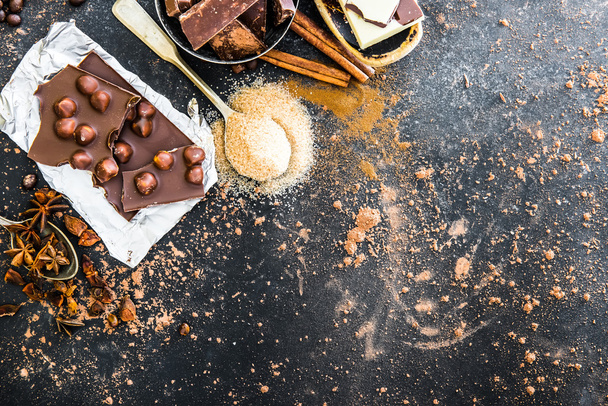 Chocolat and spices on black table - Фото, изображение