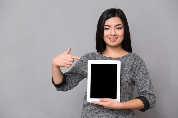 Asian girl staying and pointing on tablet - Φωτογραφία, εικόνα