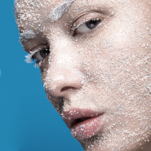 Portrait of girl with pale skin and sugar snow on her face. Creative art beauty fashion. - Photo, image
