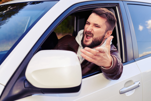 young man shouting from the window of his car - Foto, Bild