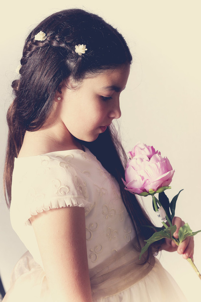 Sweet girl with communion dress holding a peony - Photo, Image
