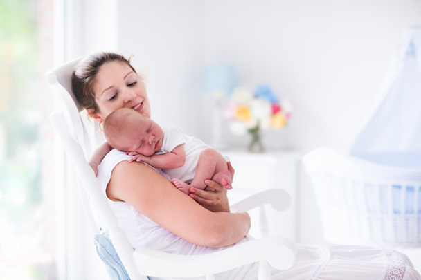 Mãe e bebê recém-nascido em berçário branco
 - Foto, Imagem