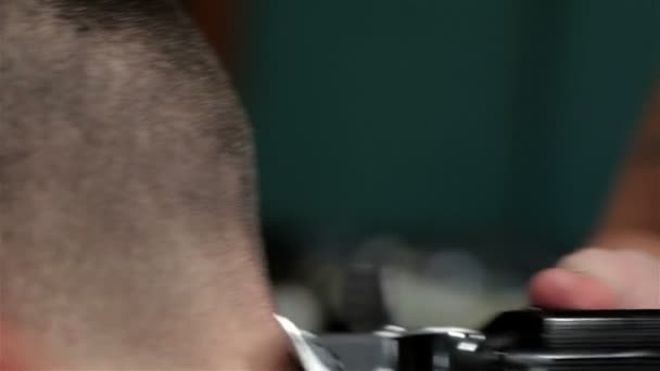 Hairstyling process, barber shaves a man - Felvétel, videó