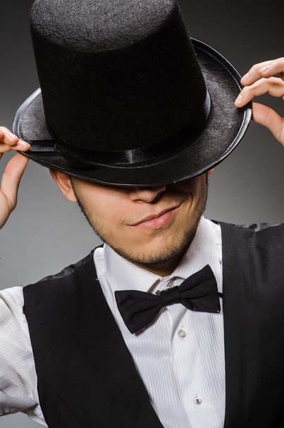 Young man in classical black vest and hat against gray - Foto, Imagen