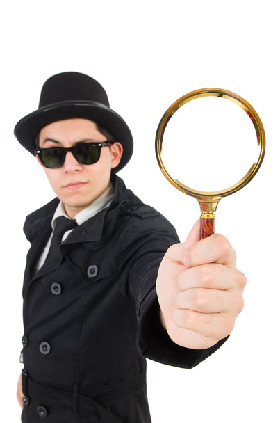 Young detective in black coat holding magnifying glass isolated - Photo, Image