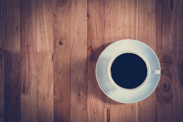 Top view of black coffee in the cup on wooden table - Фото, изображение