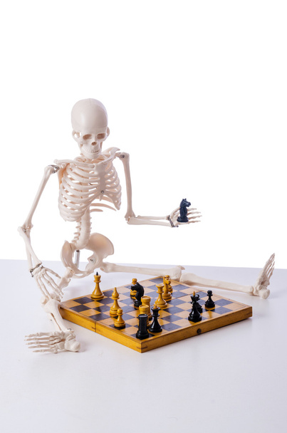 Esqueleto jogando jogo de xadrez no branco - Foto, Imagem