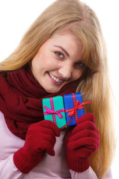 Smiling woman in woolen gloves with wrapped gifts for Christmas or other celebration - Photo, image