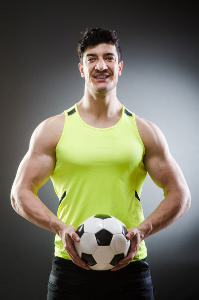 Muscular man with football ball - 写真・画像