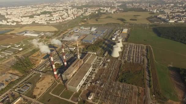 4k luchtfoto shot - vlucht over elektriciteitscentrale met pijpen in de wijk van de stad - industriële weergave - Video