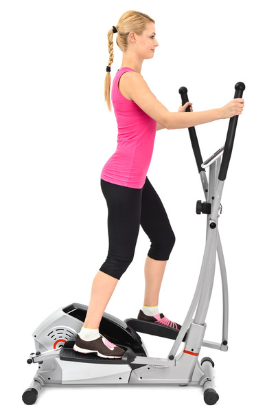 Young woman doing exercises on elliptical trainer - Photo, Image