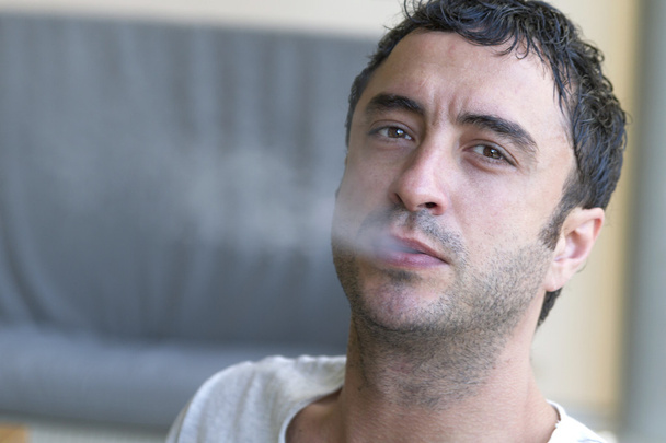 Ελκυστικά άνθρωπος καπνίζει ένα τσιγάρο - Φωτογραφία, εικόνα