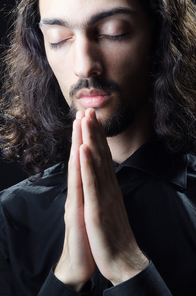 Young man praying in darkness - Valokuva, kuva