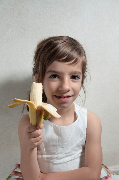 дівчина їсть бананову закуску
 - Фото, зображення