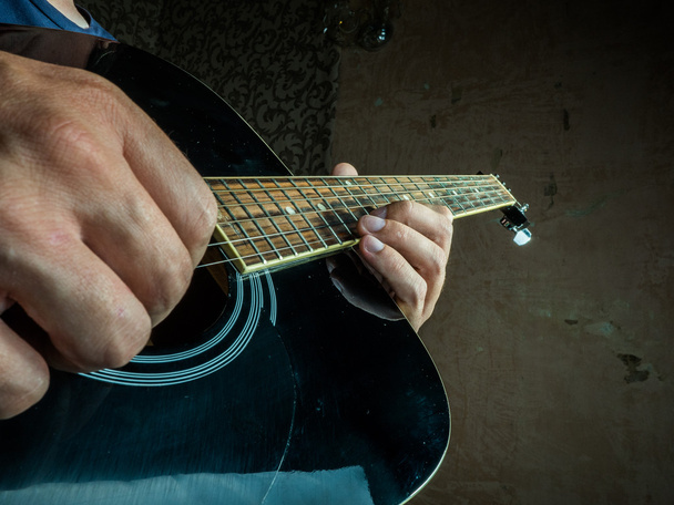 Closeup photo of an acoustic guitar played by a man. - Fotoğraf, Görsel