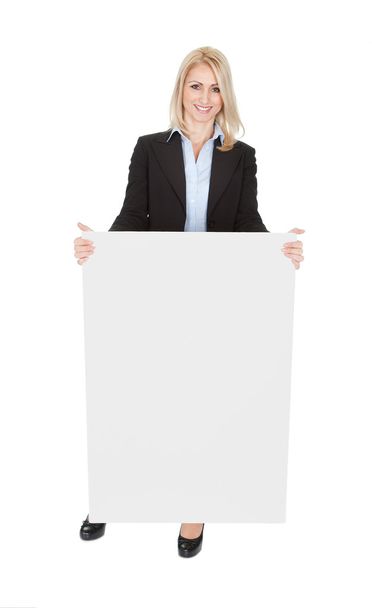 Cheerful businesswomen presenting empty board - Foto, imagen