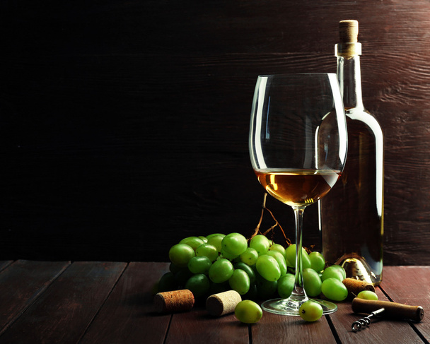 Bottle and glass of wine with grape on wooden background - Φωτογραφία, εικόνα