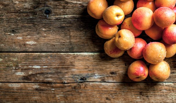 Apricot. Organic fruits with leaf on wooden background - Valokuva, kuva