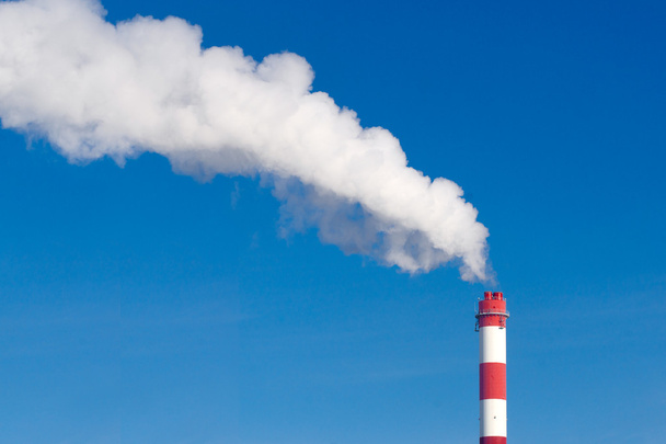 camino industriale con un sacco di fumo su un cielo blu
 - Foto, immagini
