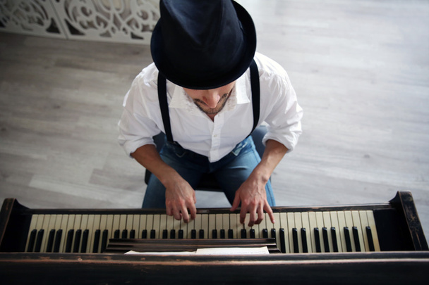 man in hat making piano music - Fotoğraf, Görsel
