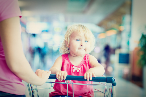 мати і мила маленька дочка на багажному візку в аеропорту
 - Фото, зображення