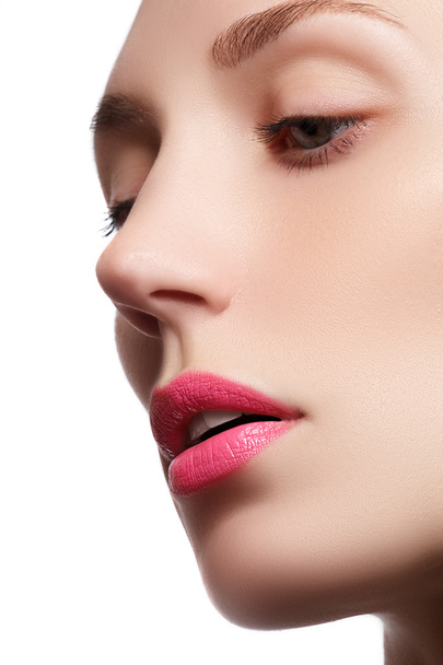 Τέλεια χείλη. Επαγγελματικό μακιγιάζ. Lipgloss. Closeup πορτρέτο του όμορφη κοπέλα. Καυκάσιος γυναίκα μοντέλο με φωτεινό μακιγιάζ με τέλεια καθαρό δέρμα με πολύχρωμα ροζ χείλη και κραγιόν - Φωτογραφία, εικόνα