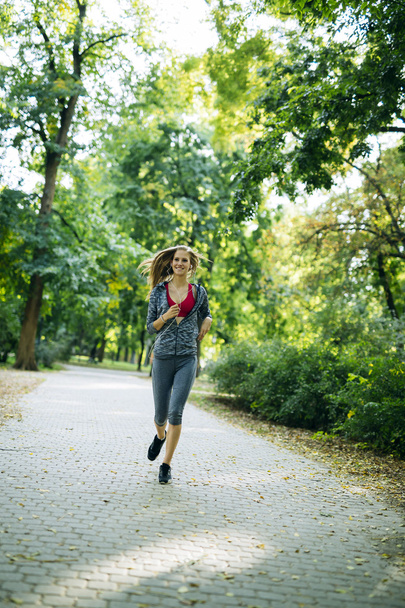 Young blonde woman jogging - Фото, изображение