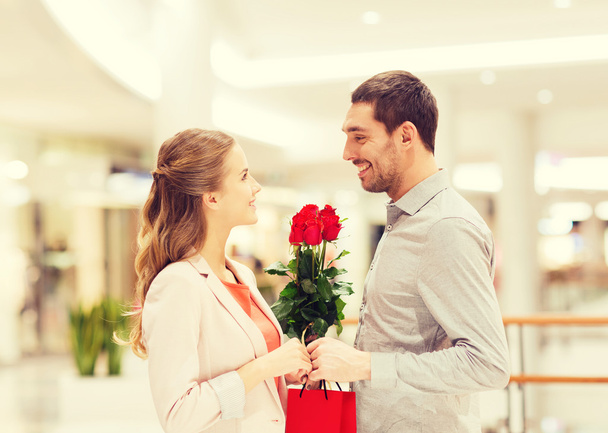 happy young couple with flowers in mall - Photo, image