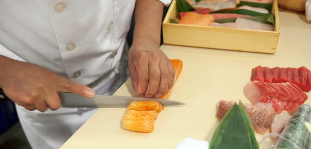 Hand was sliced fish to make sushi - Foto, Imagen