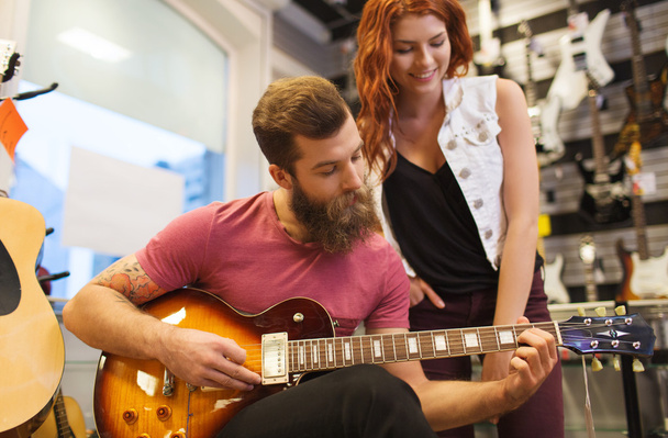 couple of musicians with guitar at music store - Photo, Image