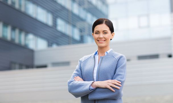 young smiling businesswoman over office building - Foto, immagini