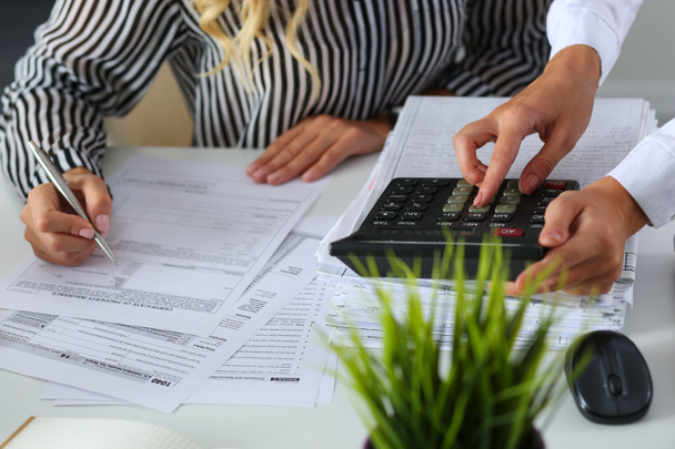 Deux femmes comptables comptant sur une calculatrice
 - Photo, image